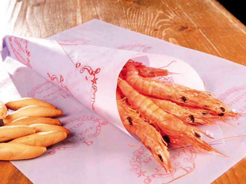 Gambas y galletas sobre papel con dibujos.