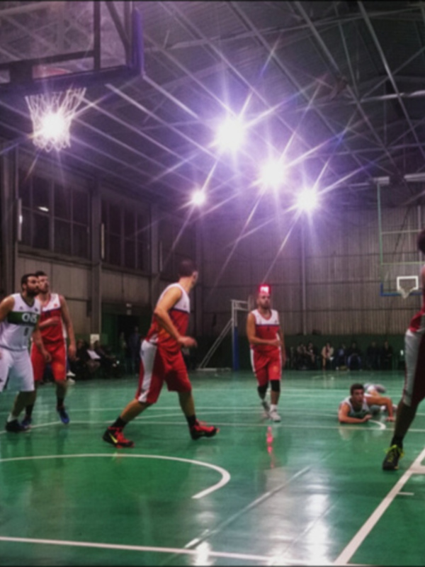 Jugadores de baloncesto en acción durante un partido en un pabellón deportivo de Sevilla.