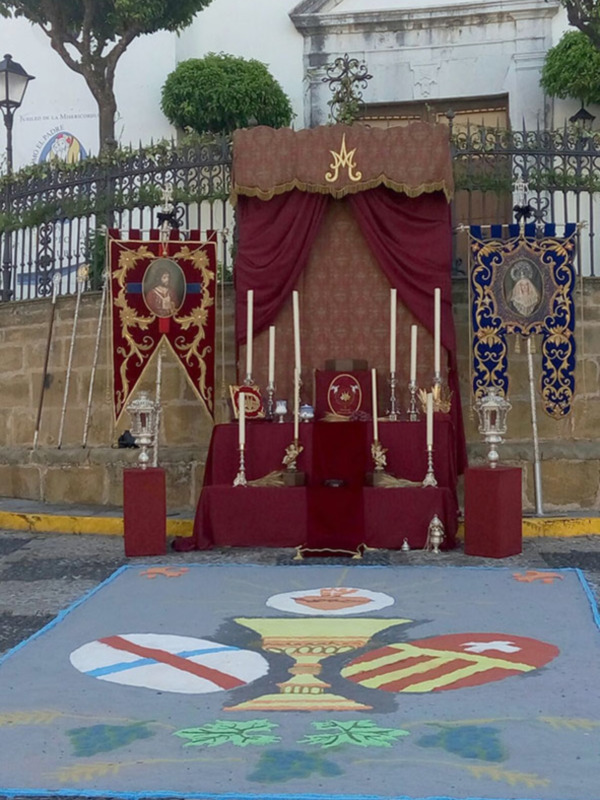 Escenario procesional con estandartes y altar, típico de las procesiones religiosas en España.