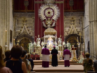 Eucaristía en la Catedral de Sevilla, España, con sacerdotes y fieles en una ceremonia religiosa.