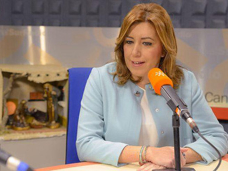A una mujer sentada en un escritorio, con un micrófono enfrente de ella. La escena parece ser una entrevista o conferencia de prensa en un entorno profesional.
