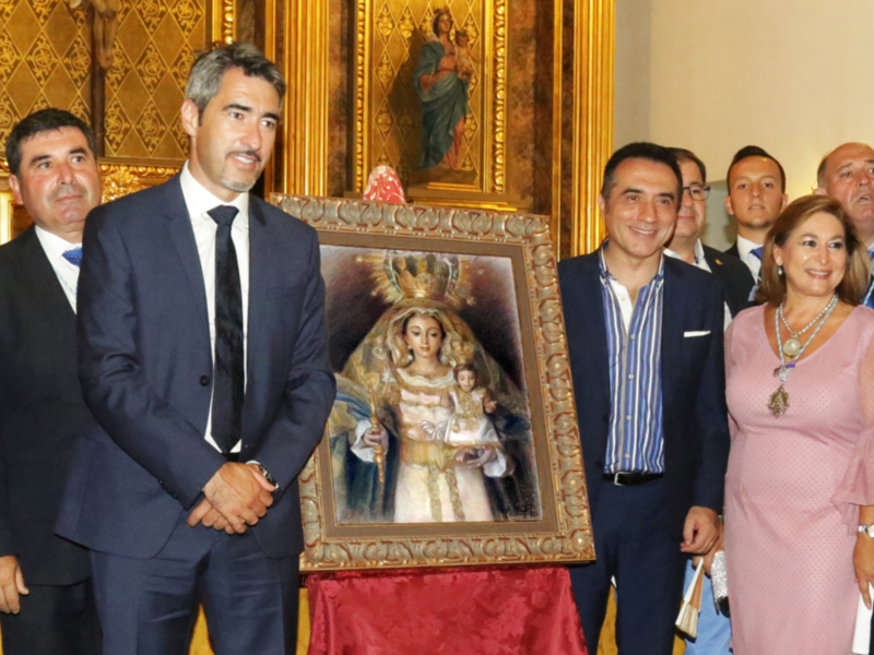 Celebración con autoridades y una imagen religiosa en un ambiente formal.