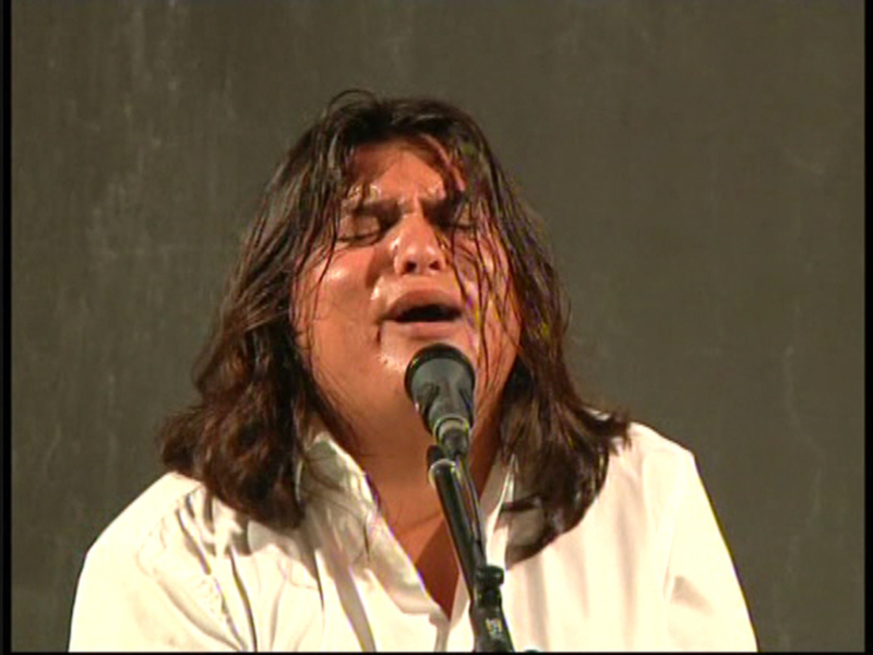 Persona cantando con pasión y expresión en un escenario.