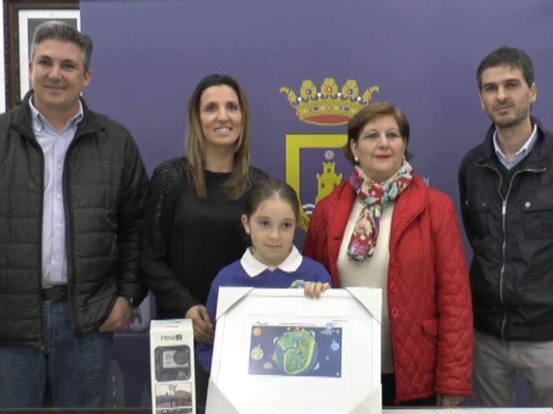 Una familia sonríe frente a una bandera de la ciudad, con un niño en el centro sosteniendo un dibujo sobre un tablet.