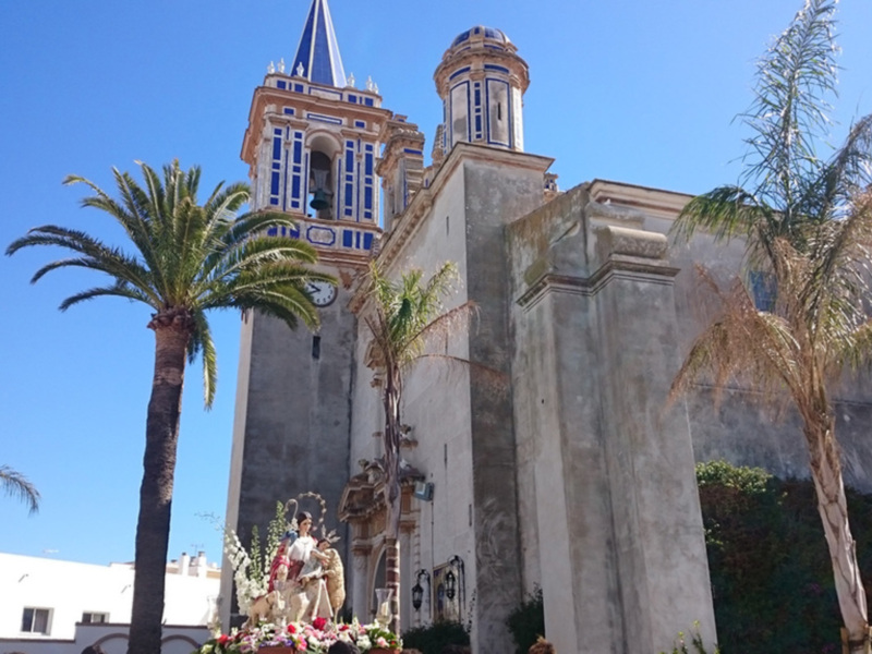 Torre de la iglesia con palmeras y cielo azul claro