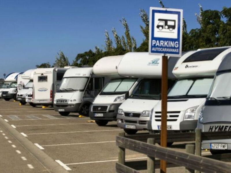 Parking para autocaravanas, con varios vehículos de recreación en fila.