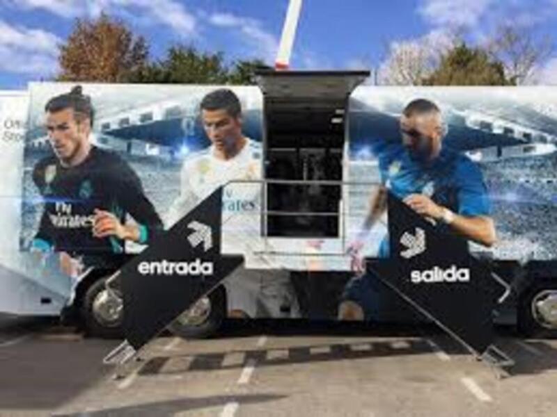 Un autobús de fútbol con imágenes de jugadores y la inscripción "Entrada" y "Salida".