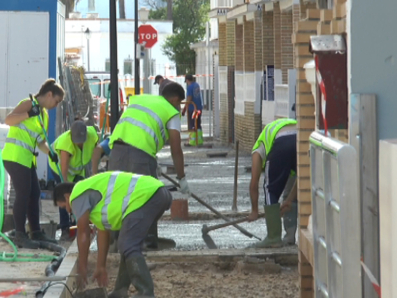 Trabajadores en uniforme de construcción trabajando en la calle.