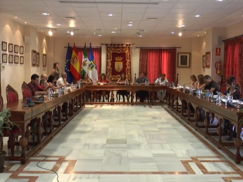 Sala de conferencias con mesa central, banderas y carteles decorativos.