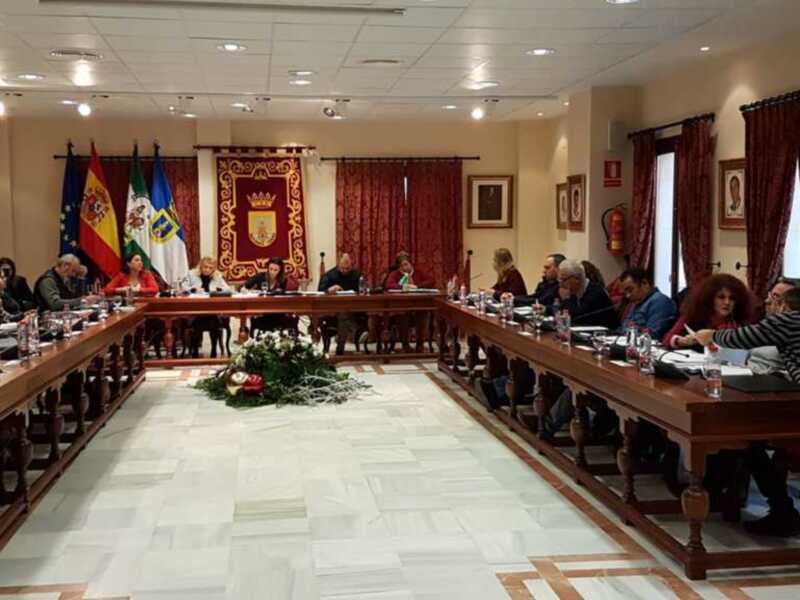 Sala de reuniones con una mesa larga central, sillas para los asistentes y banderas en el fondo.