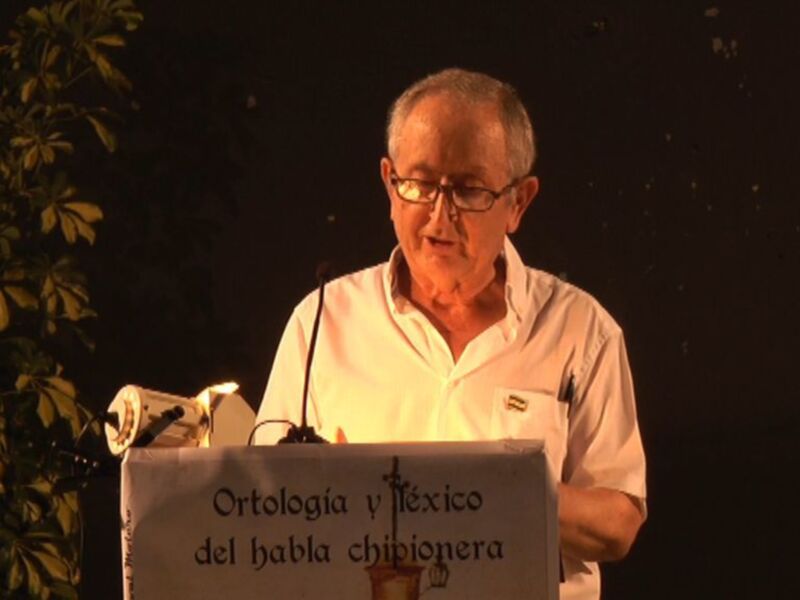 El hombre en el escenario está pronunciando un discurso sobre ortología y teoría del habla chibionera.