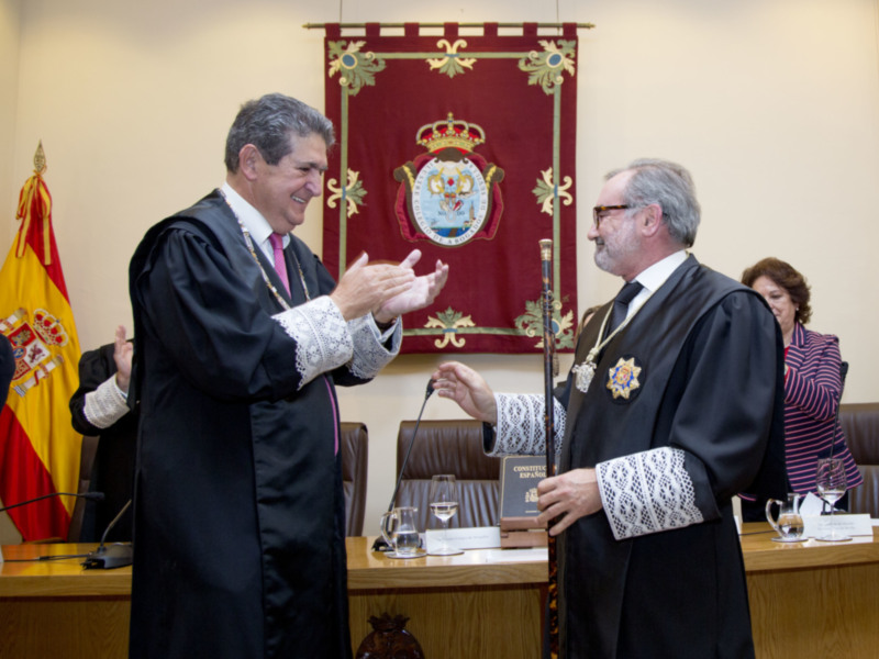 Celebración formal en un tribunal con magistrados intercambiando gestos en un ambiente solemne.