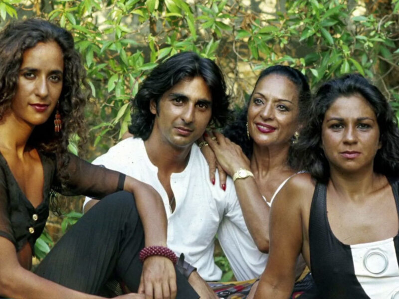 Cuatro personas posando juntos al aire libre, rodeadas de vegetación verde.