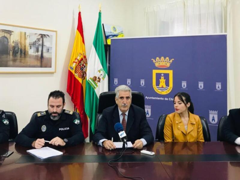 Presentación de un informe gubernamental en una sala de conferencias con banderas y oficiales.