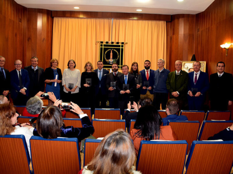 Conferencia y entrega de premios en un auditorio con asistentes y participantes en trajes formales.