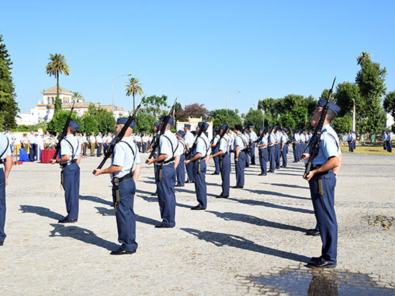 Uniformados en formación en un patio de armas, bajo un cielo azul claro.