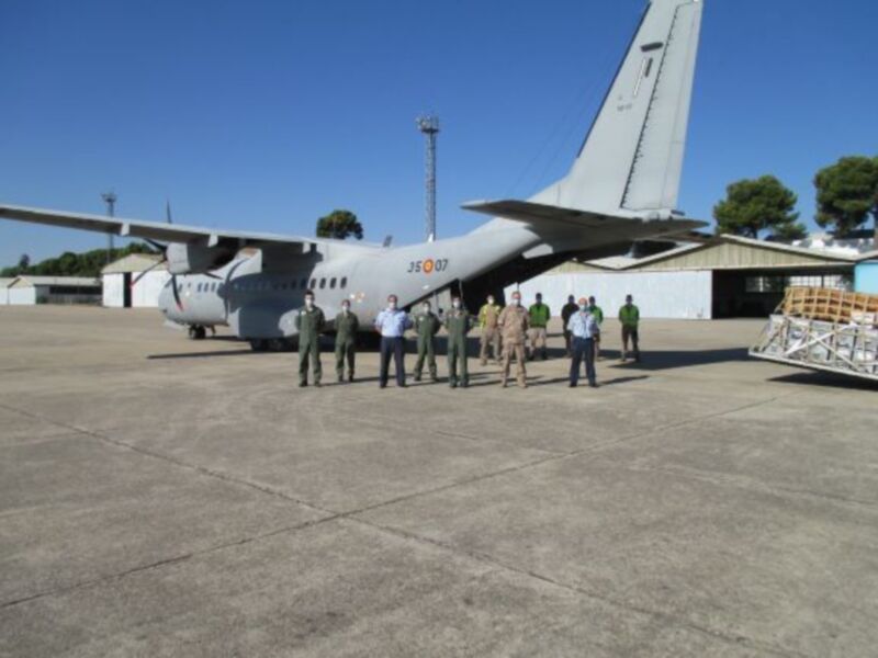 Equipo militar en un aeropuerto, posando frente a un avión militar. El avión tiene el número 35-07 en la parte trasera. El equipo está vestido con uniformes militares y los árboles y el cielo azul forman el fondo.