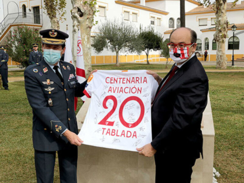 Celebración del centenario de la aviación en Tablada, con uniformes y una bandera conmemorativa.