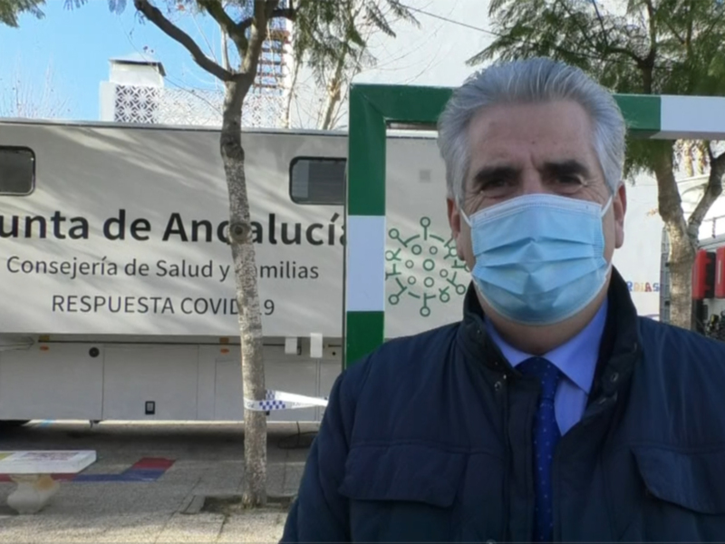 Un hombre con una máscara médica frente a un camión de la Junta de Andalucía, que anuncia la respuesta al COVID-19.
