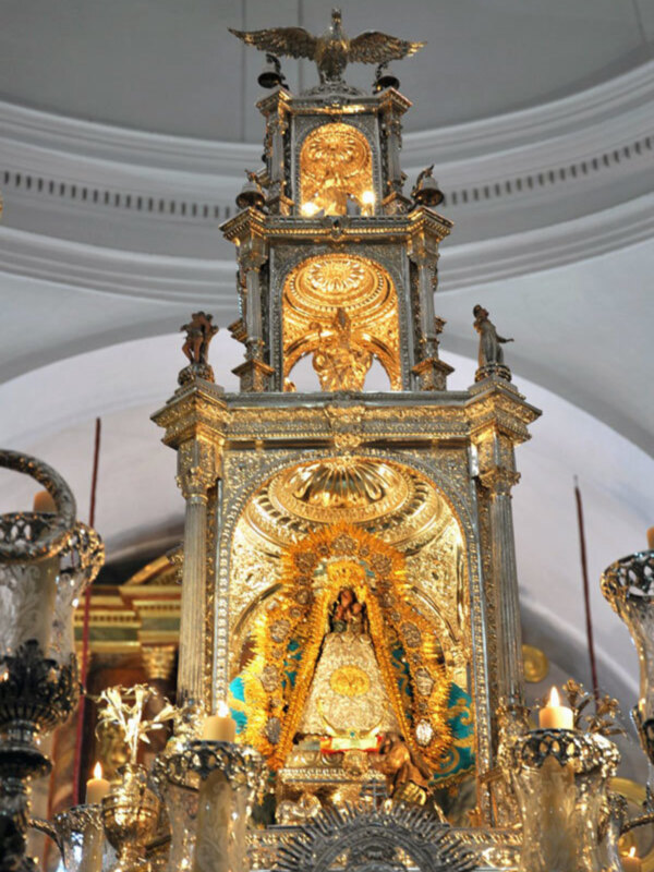 Altar con ornamentos dorados y velas encendidas en un ambiente religioso