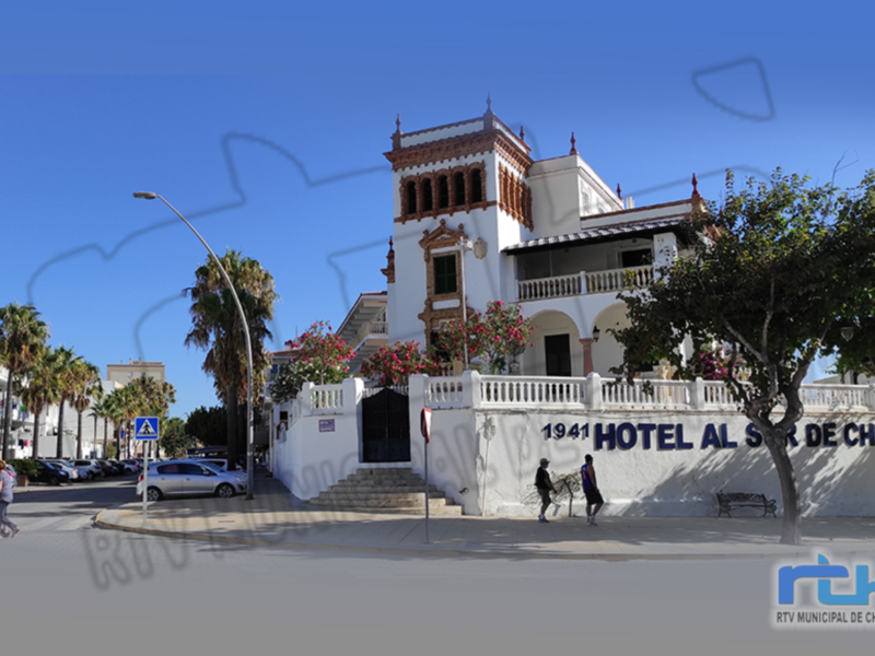 Hotel Al Sur de Chipiona, edificio histórico con balcones y palmeras al lado.