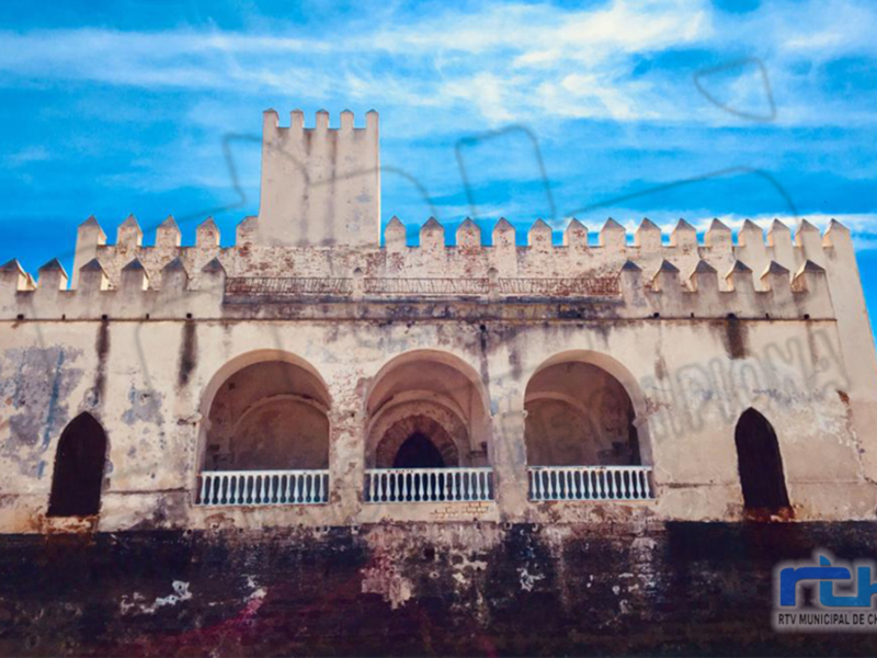 El castillo de Chipiona, una fortaleza histórica ubicada en la costa de Cádiz, España, con su arquitectura mediterránea y el cielo azul claro al fondo.