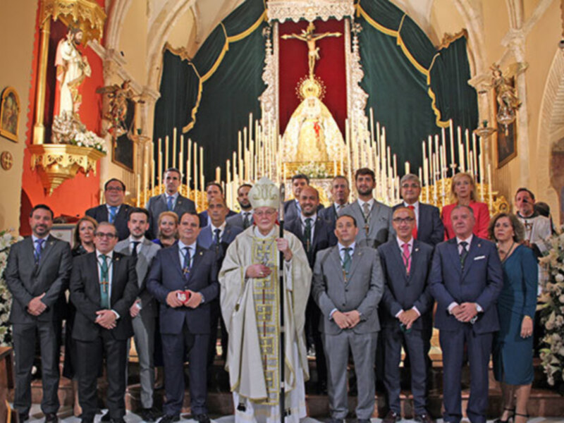 Celebración religiosa en una iglesia con un sacerdote y una multitud formalmente vestida.