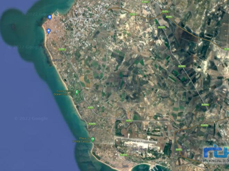 Imagen satelital de una ciudad costera con áreas urbanas y rurales.