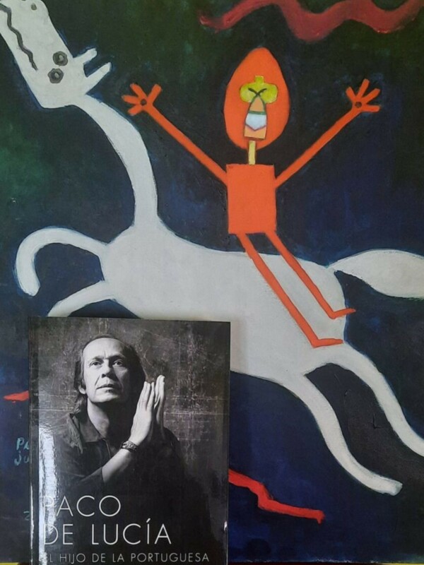 Un libro con una ilustración de un personaje rojo y blanco en el fondo, junto a otro libro con una imagen de un hombre.