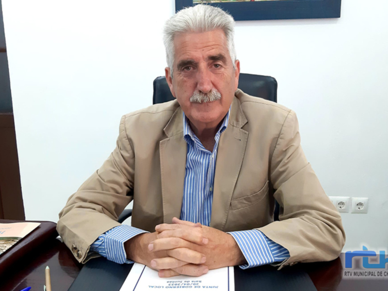 Persona sentada en un escritorio con documentos, en un entorno de oficina.
