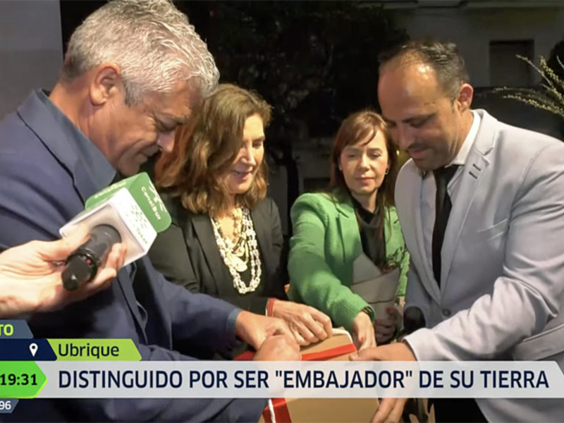 Persona siendo distinguida como 'Embajador de su Tierra' en una ceremonia en Ubrique, Cádiz.