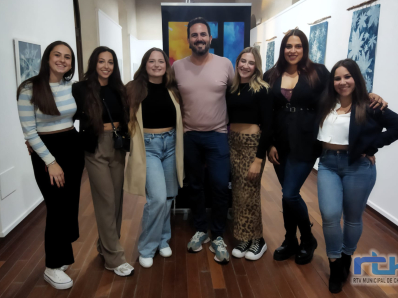 Grupo de personas posando en una sala con arte en las paredes. El ambiente es casual y amigable. El texto en la imagen dice 'RTV MUNICIPAL DE CHIPIONA'.