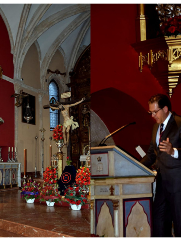 Un hombre en traje habla en un púlpito en una iglesia con arcos y altares decorados.