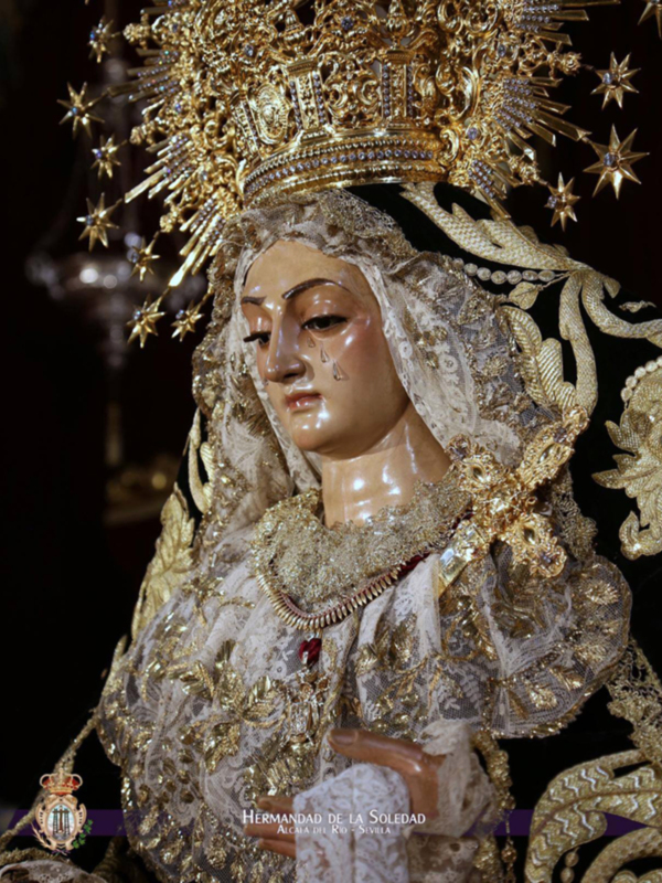 Imponente imagen de la Virgen de la Soledad, vestida con traje de luto y corona dorada, representando su dolor y esplendor.