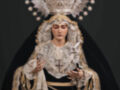 Imagen de una Virgen María vestida con trajes tradicionales, incluyendo una corona y un manto negro bordado.